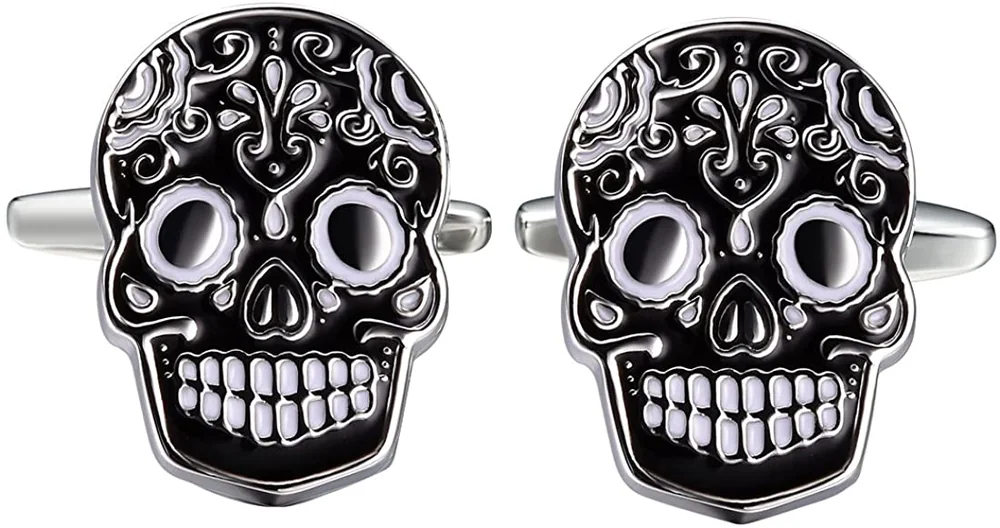 Black skull-shaped cufflinks with silver-tone floral scrollwork and white facial details