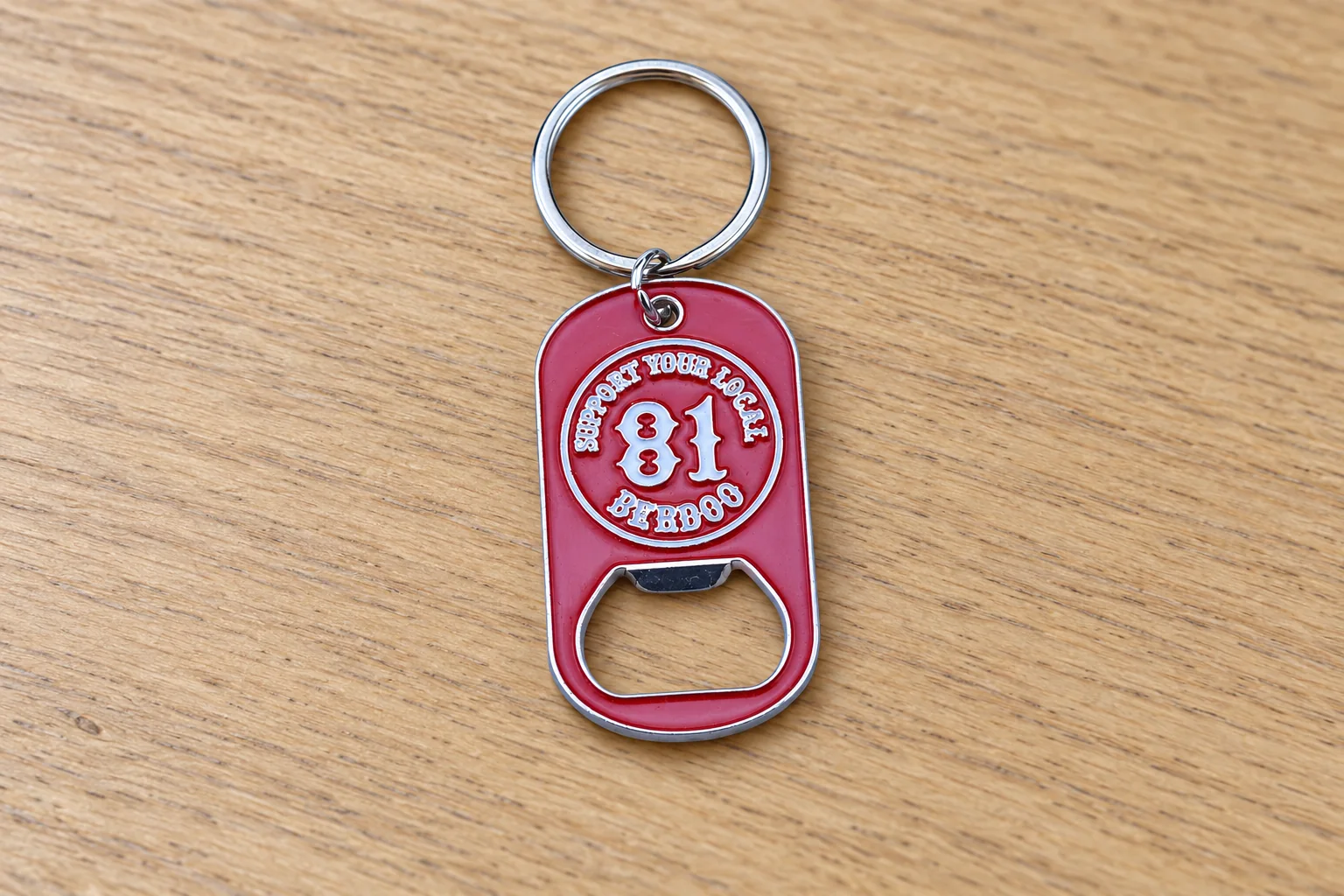 Red rectangular metal bottle opener keychain with a white 81 design and split-ring attachment