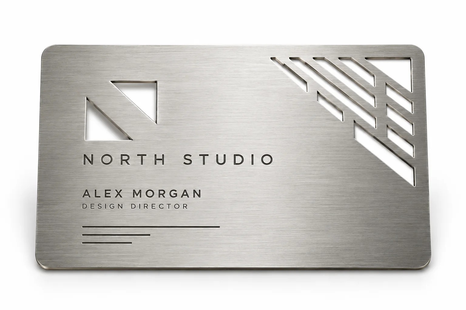 Brushed silver metal business card with geometric cutouts, engraved lettering, and rounded corners on a white background