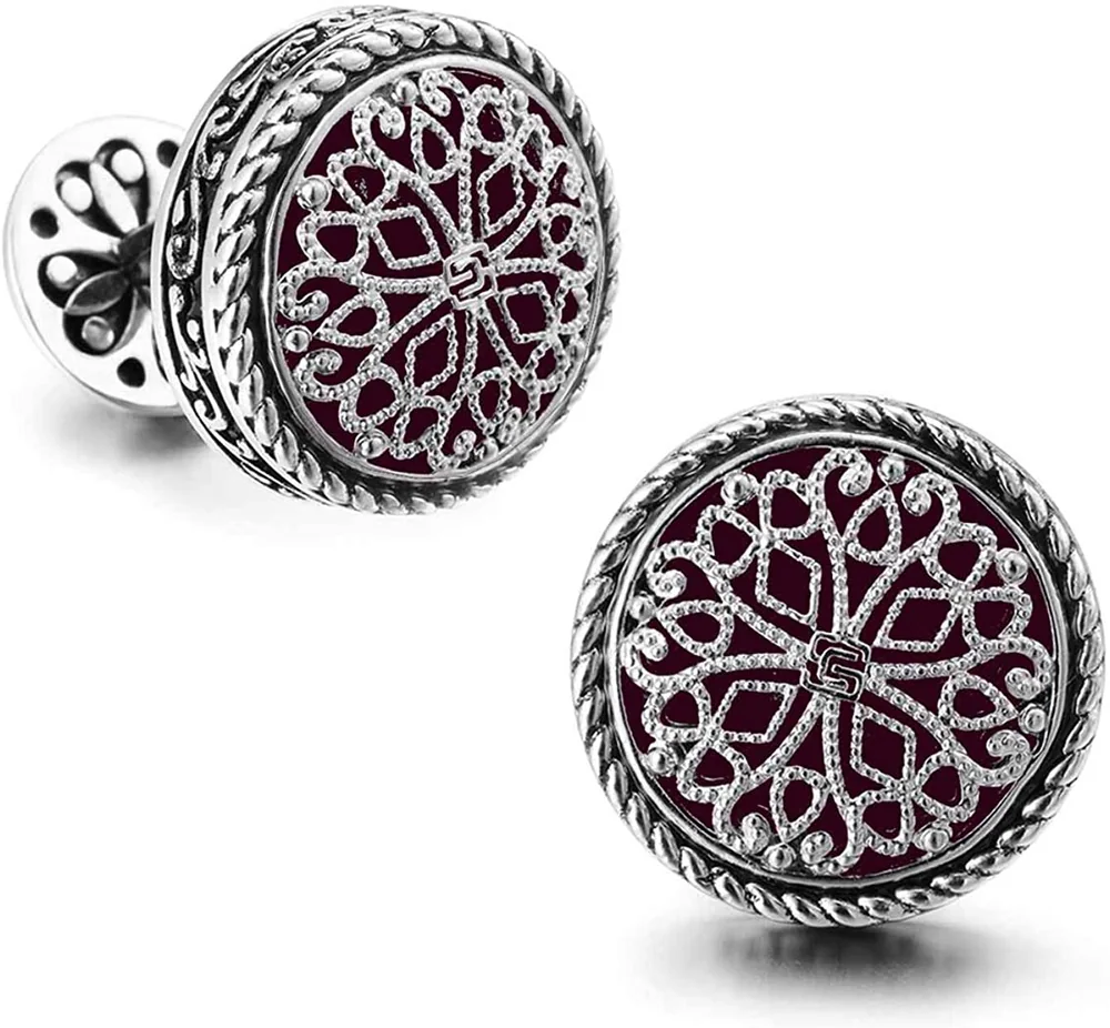 Round silver-tone cufflinks with ornate filigree patterns over deep red centers on a white background
