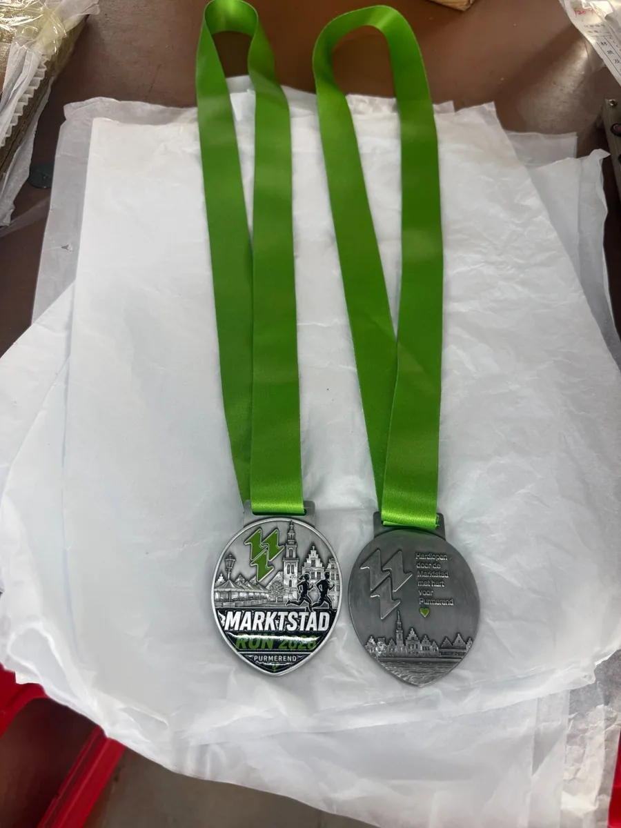 Front and reverse of the Marktstad Run 2026 medal with green ribbons