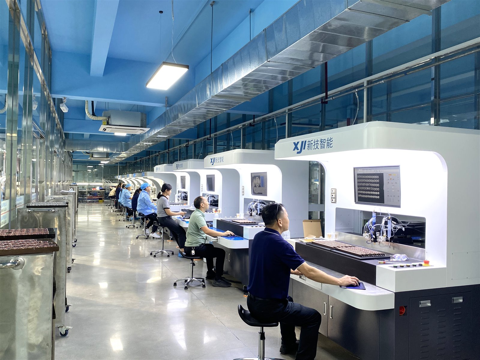 Technicians operating automated coloring equipment inside the Unique Pin factory