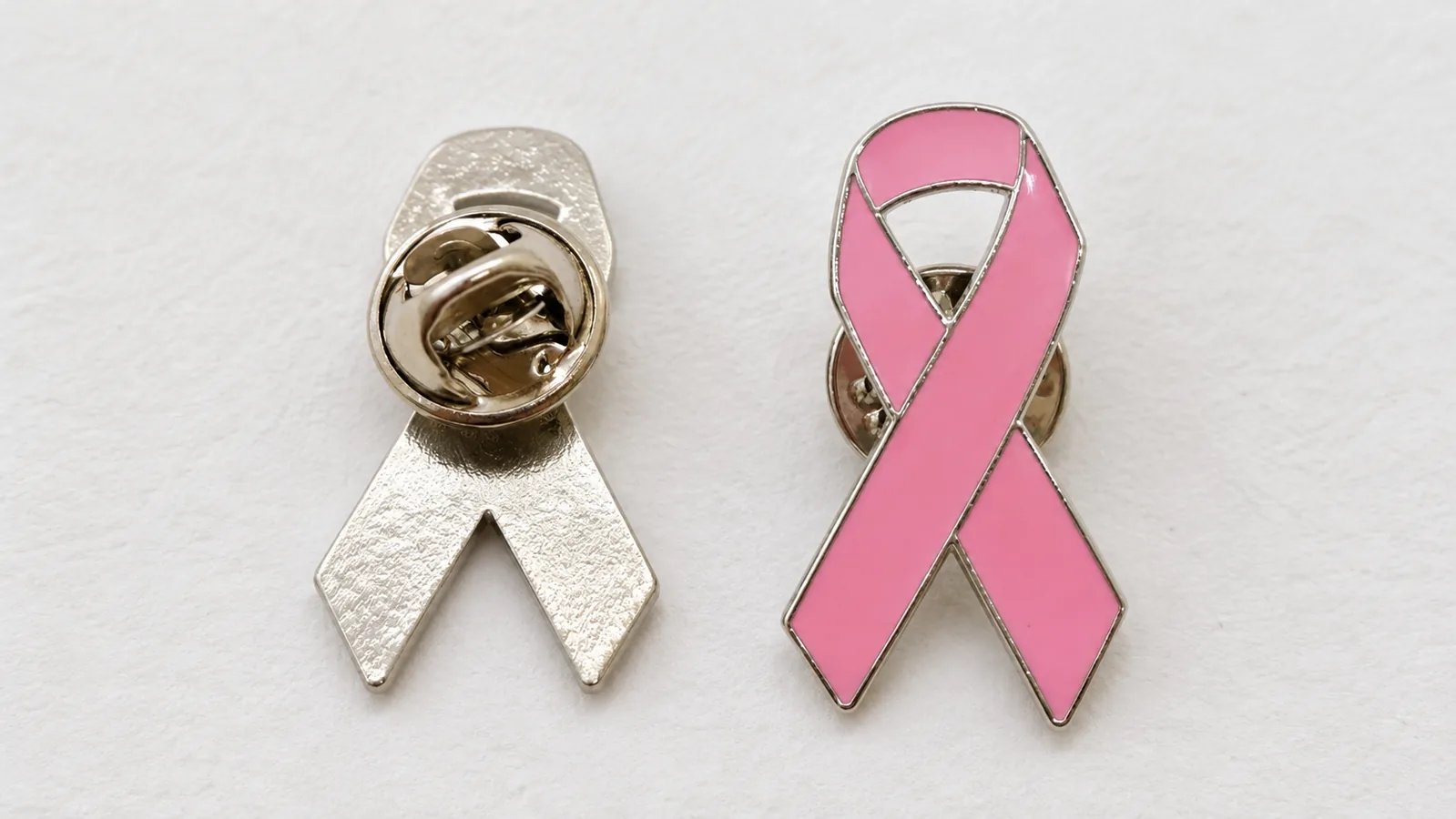 Front and back of a pink ribbon lapel pin with a metal border and clutch backing
